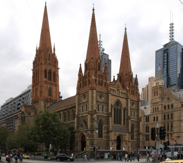 historical-landmarks-with-melbourne-tours a group of people in front of a large church with St Paul's Cathedral, Melbourne in the background